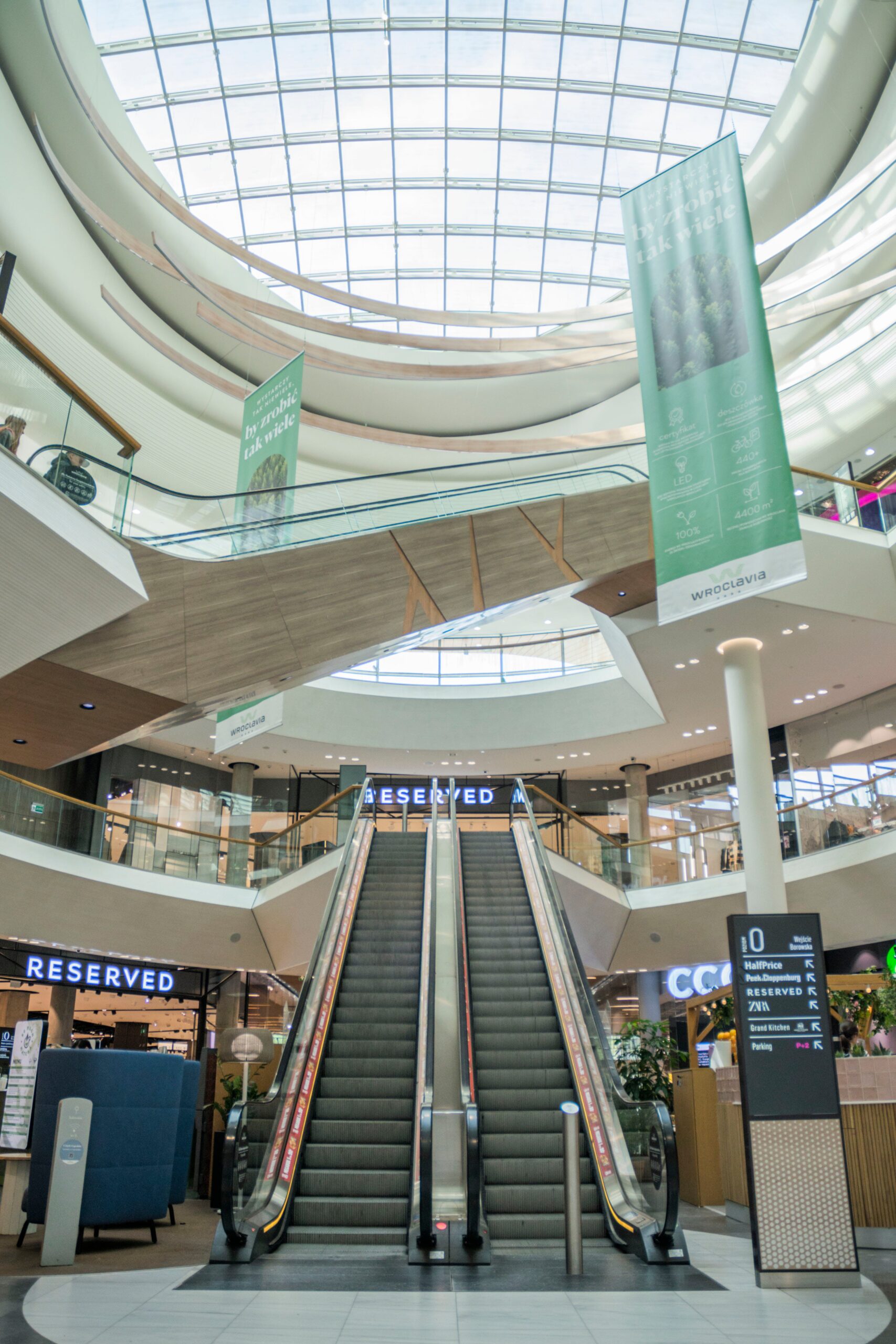 Wide view of a modern shopping mall escalator in Wrocław, Poland.